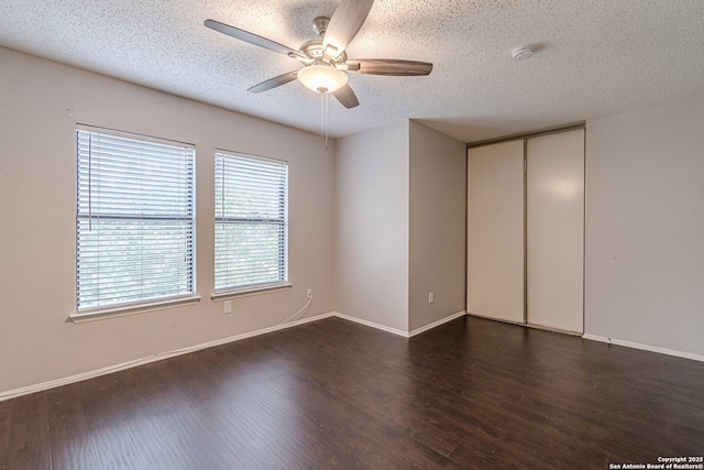 unfurnished room featuring a textured ceiling, dark hardwood / wood-style floors, and ceiling fan