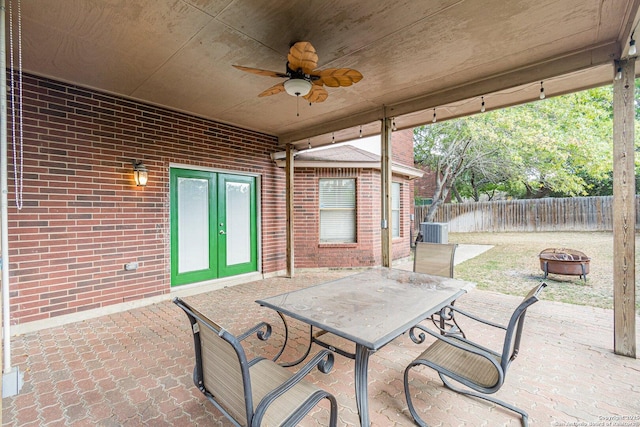 view of patio with french doors, ceiling fan, central AC, and a fire pit