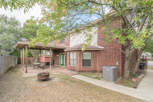 back of house featuring a patio area, central air condition unit, and an outdoor fire pit