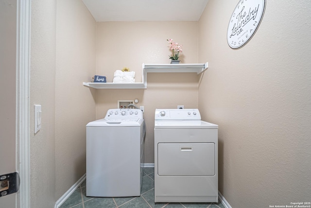 clothes washing area featuring tile patterned floors and washing machine and clothes dryer