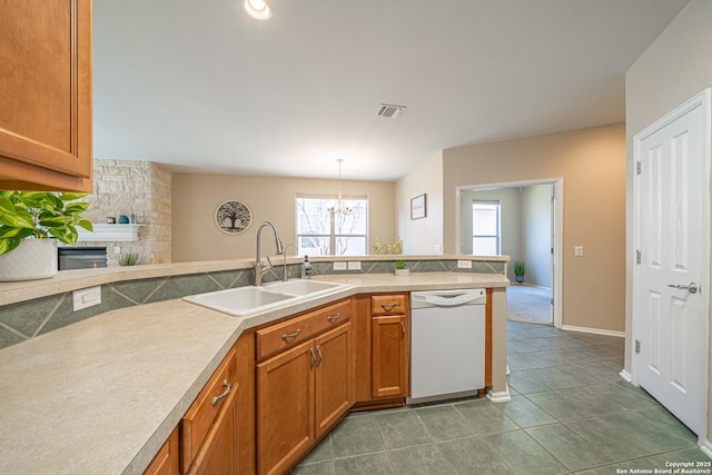 kitchen with a fireplace, sink, hanging light fixtures, white dishwasher, and kitchen peninsula