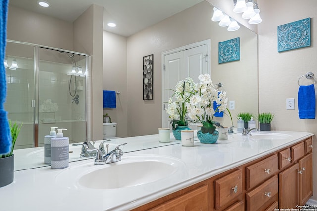 bathroom with vanity, toilet, and a shower with door