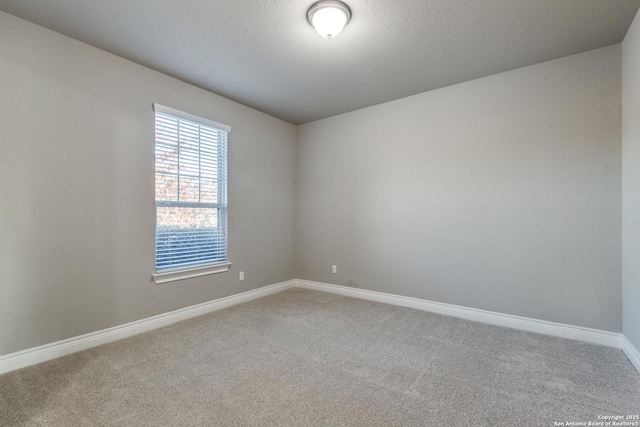 carpeted empty room with a textured ceiling