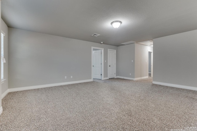 spare room with a textured ceiling and carpet flooring