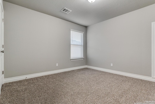 carpeted spare room featuring a textured ceiling