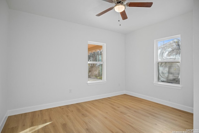 spare room with ceiling fan, plenty of natural light, and light wood-type flooring