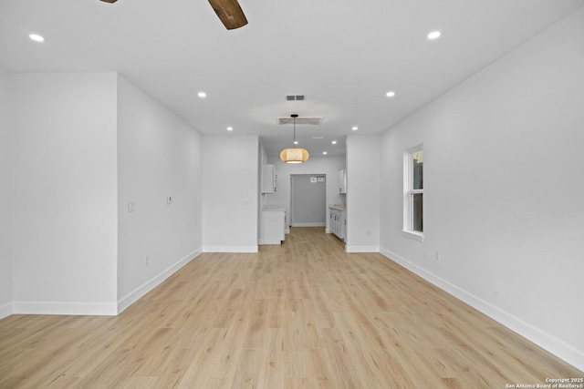 unfurnished living room featuring ceiling fan and light wood-type flooring