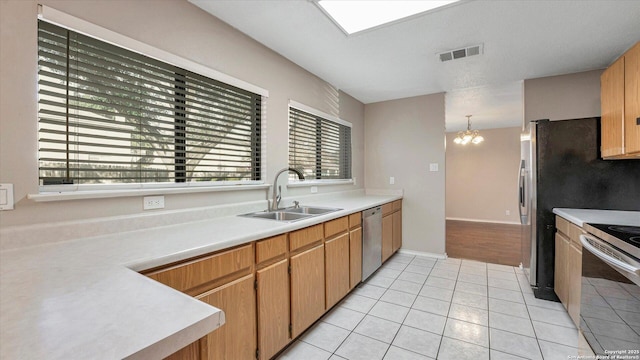 kitchen featuring light tile patterned flooring, appliances with stainless steel finishes, decorative light fixtures, sink, and a chandelier