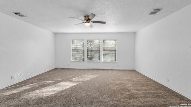 empty room with ceiling fan, carpet floors, and a textured ceiling