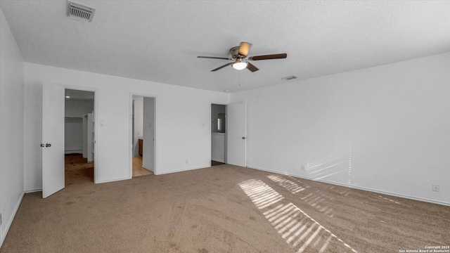 unfurnished bedroom with ceiling fan, light colored carpet, and a textured ceiling