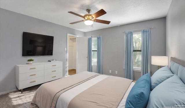 carpeted bedroom with a textured ceiling and ceiling fan