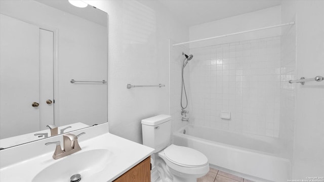 full bathroom featuring tiled shower / bath, vanity, toilet, and tile patterned flooring