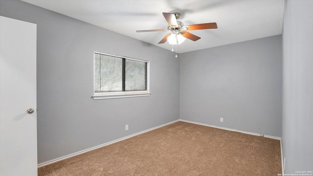 spare room with ceiling fan and light colored carpet