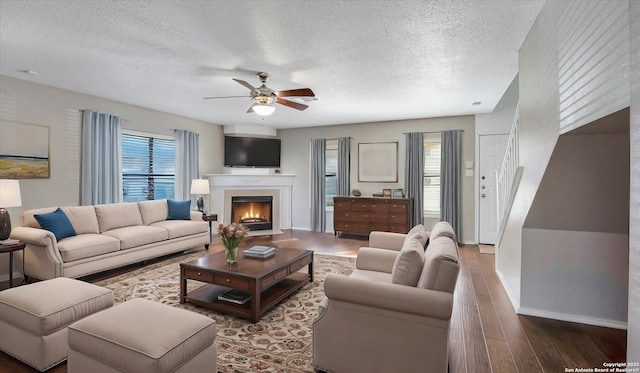 living room with ceiling fan, plenty of natural light, hardwood / wood-style floors, and a textured ceiling