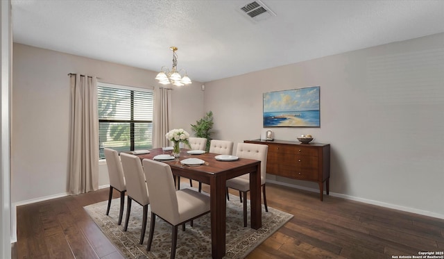 dining space with a textured ceiling, a notable chandelier, and dark hardwood / wood-style flooring