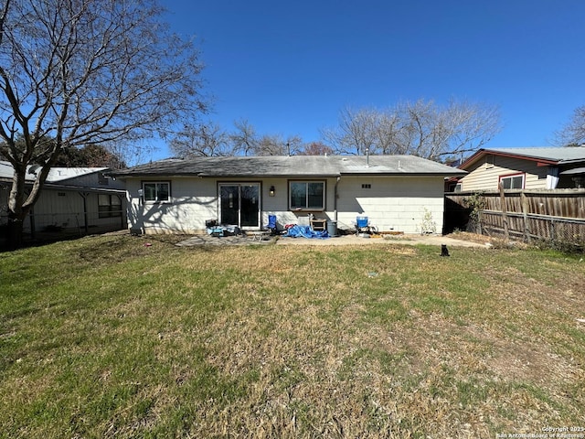 rear view of property with a lawn