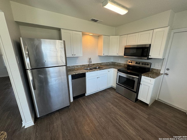 kitchen featuring stainless steel appliances, sink, white cabinets, and dark hardwood / wood-style floors