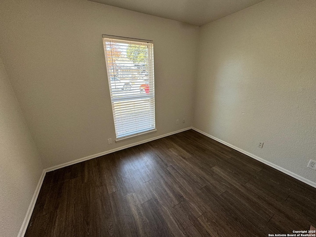 spare room with dark wood-type flooring