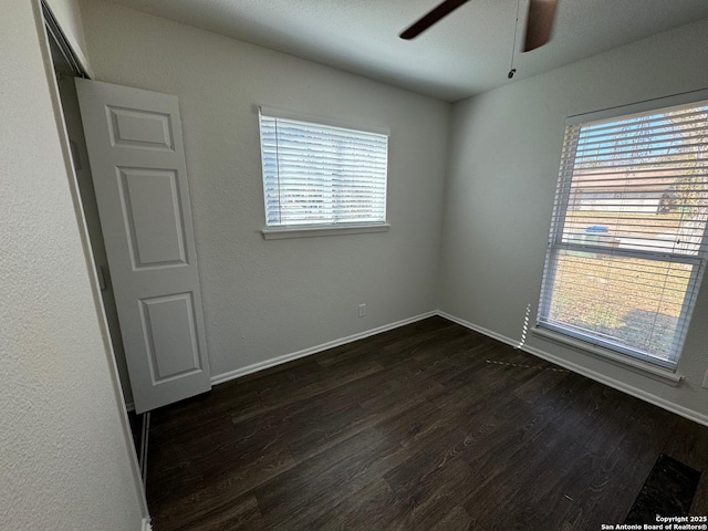 spare room featuring dark wood-type flooring and ceiling fan