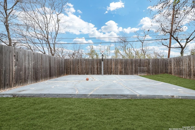 view of basketball court with a yard