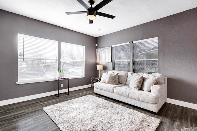 living room featuring ceiling fan and dark hardwood / wood-style floors