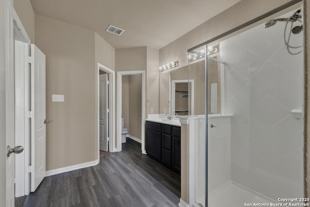 bathroom with vanity, wood-type flooring, toilet, and walk in shower