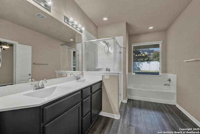 bathroom with vanity, hardwood / wood-style flooring, and plus walk in shower