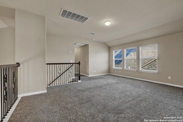 unfurnished room featuring lofted ceiling and carpet floors