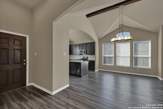 foyer with vaulted ceiling, dark wood-type flooring, and an inviting chandelier