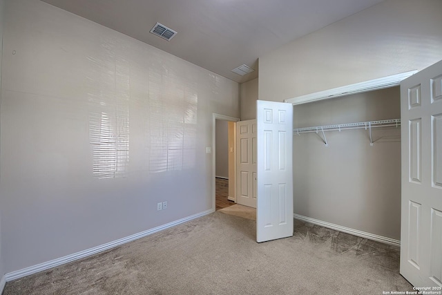 unfurnished bedroom with light colored carpet and a closet