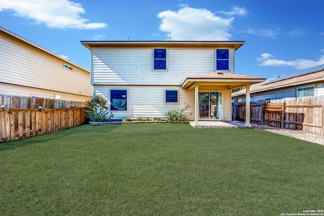 back of property with a lawn and a patio area