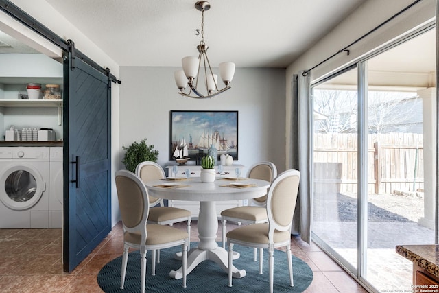 tiled dining space with separate washer and dryer, a barn door, and a notable chandelier