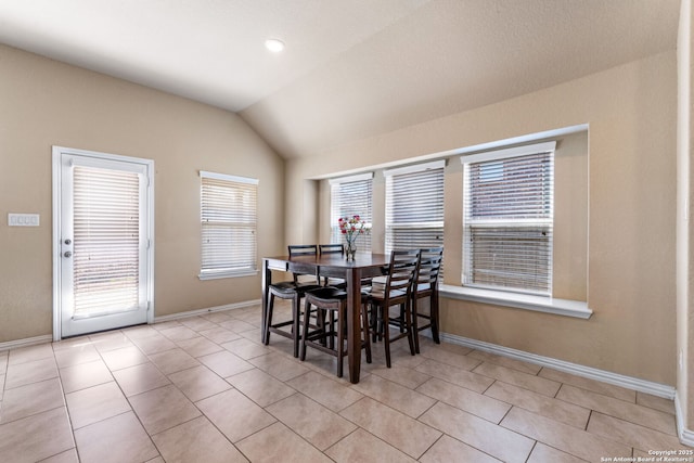 tiled dining space with lofted ceiling