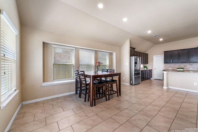 tiled dining room featuring lofted ceiling