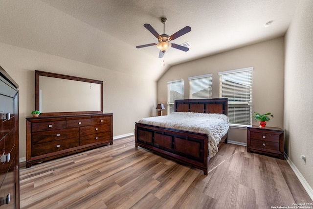 bedroom featuring vaulted ceiling, ceiling fan, and light hardwood / wood-style flooring