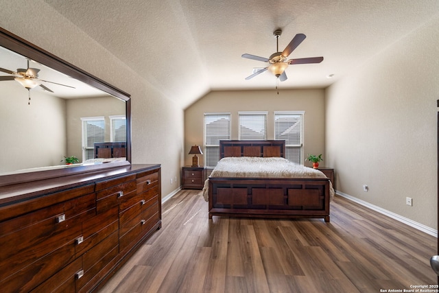 bedroom featuring a textured ceiling, vaulted ceiling, dark hardwood / wood-style floors, and ceiling fan