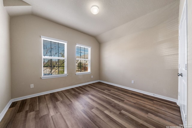 spare room with lofted ceiling and dark hardwood / wood-style floors