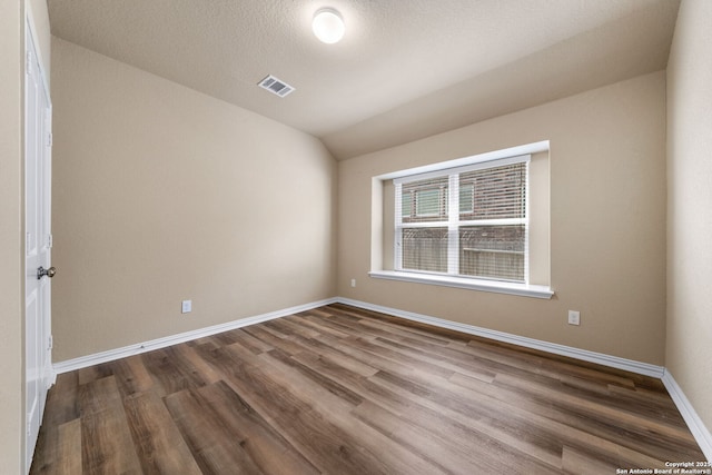 spare room featuring hardwood / wood-style flooring and a textured ceiling