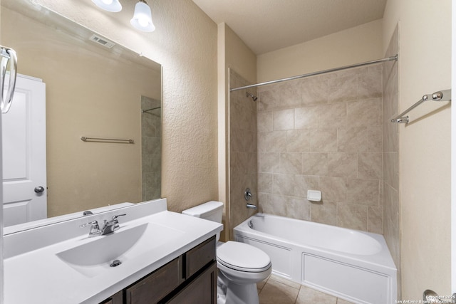 full bathroom featuring tiled shower / bath, vanity, toilet, and tile patterned flooring