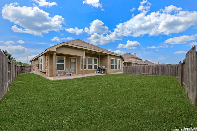 back of property featuring a yard and a patio area