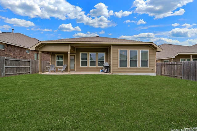 rear view of house with a lawn and a patio