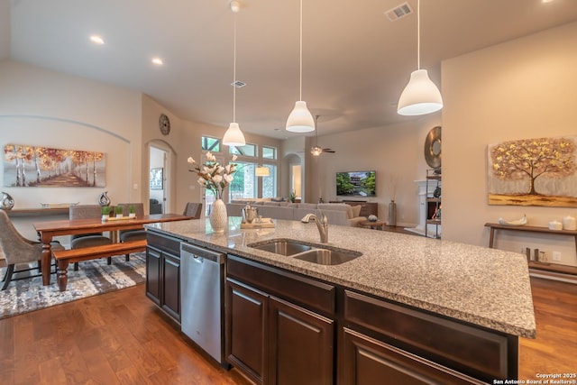 kitchen featuring sink, light stone countertops, a center island with sink, decorative light fixtures, and stainless steel dishwasher