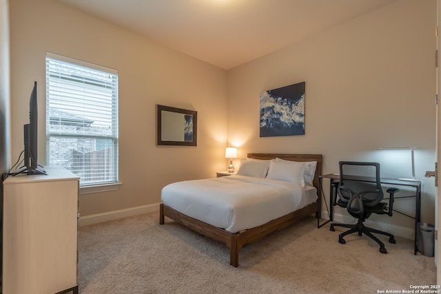 bedroom with light carpet and multiple windows