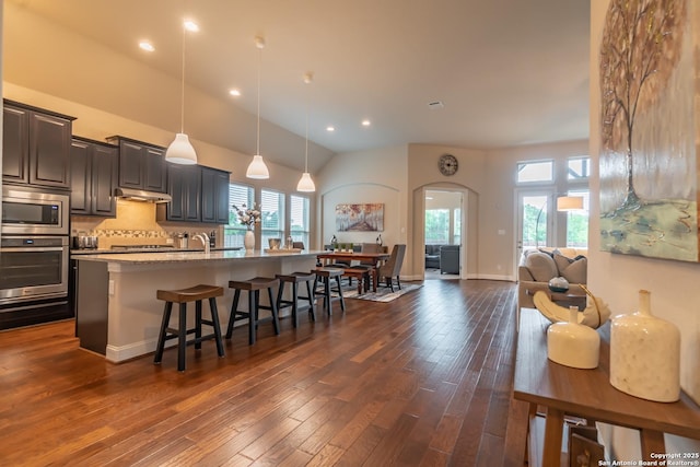 kitchen with appliances with stainless steel finishes, an island with sink, a breakfast bar area, and a wealth of natural light