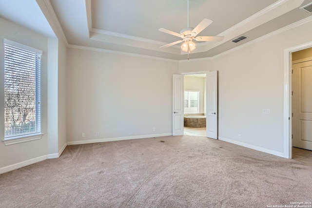 spare room with ceiling fan, ornamental molding, a raised ceiling, and light carpet