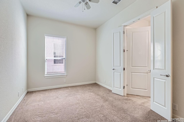 carpeted spare room featuring ceiling fan