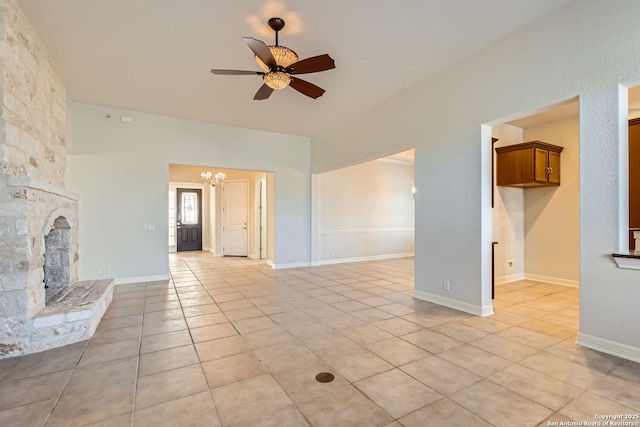 unfurnished living room with light tile patterned floors, ceiling fan with notable chandelier, and a fireplace