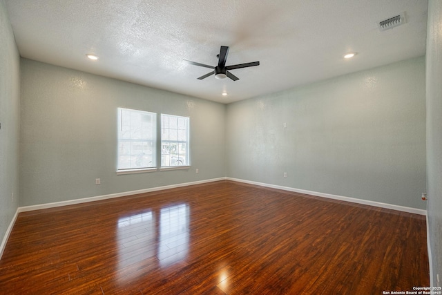 spare room with dark wood-type flooring, a textured ceiling, and ceiling fan