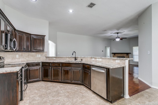 kitchen featuring sink, ceiling fan, appliances with stainless steel finishes, backsplash, and dark brown cabinets