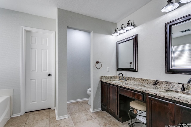 bathroom featuring vanity, a tub to relax in, tile patterned floors, and toilet